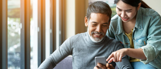 man and woman looking at phone